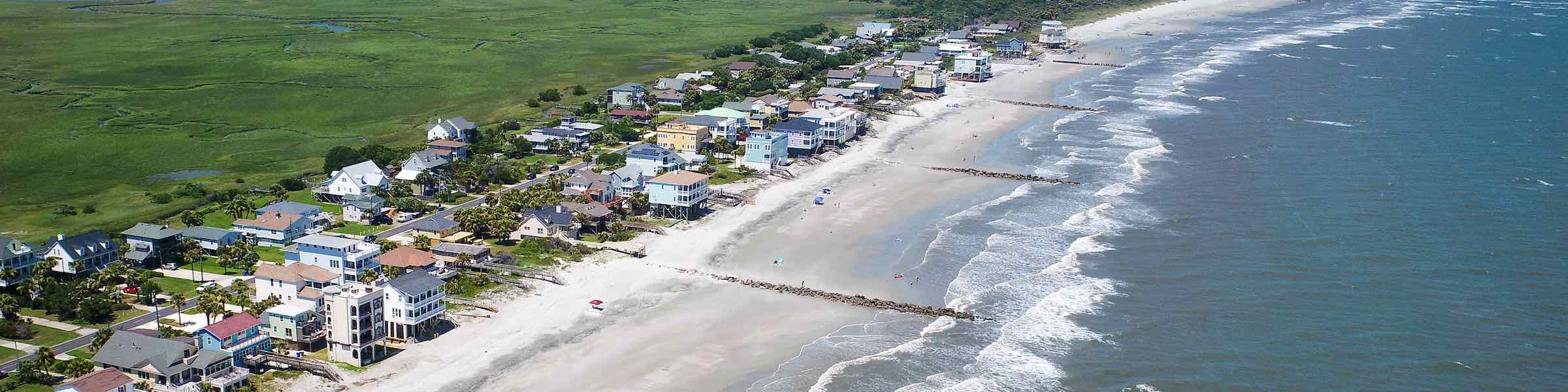 Aerial view of beach houses and marsh at Folly Beach, SC.